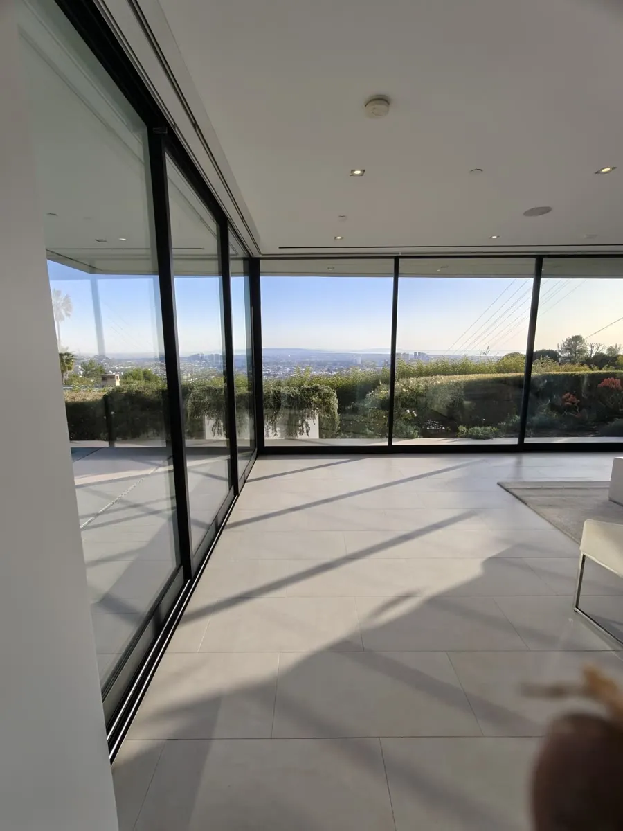 Fleetwood corner sliding door system from inside the home after service, opening to city views in Los Angeles