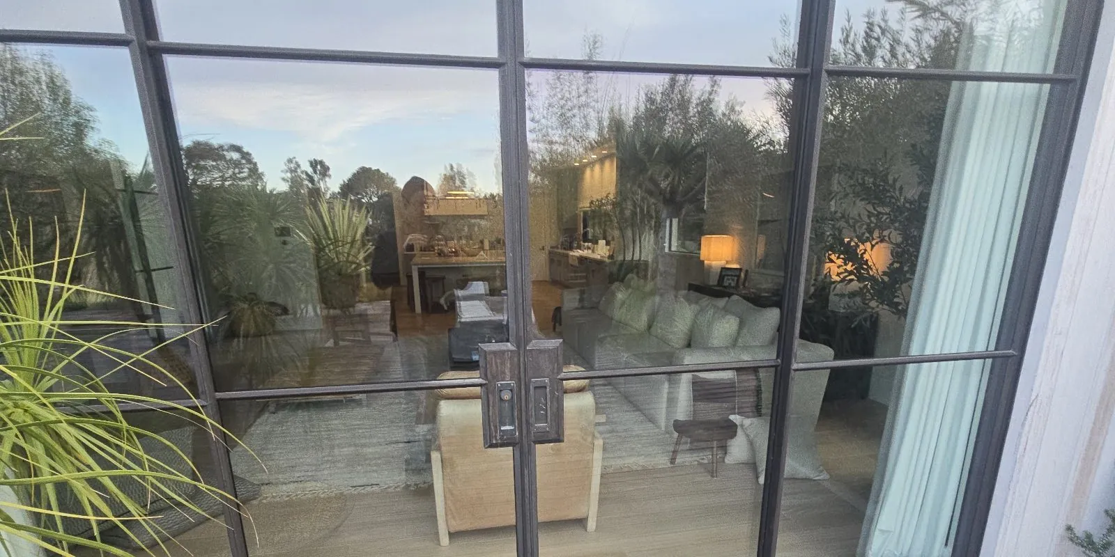 Fleetwood steel-look grid door wall at dusk in a Los Angeles home, installed by Versa Glass Co.
