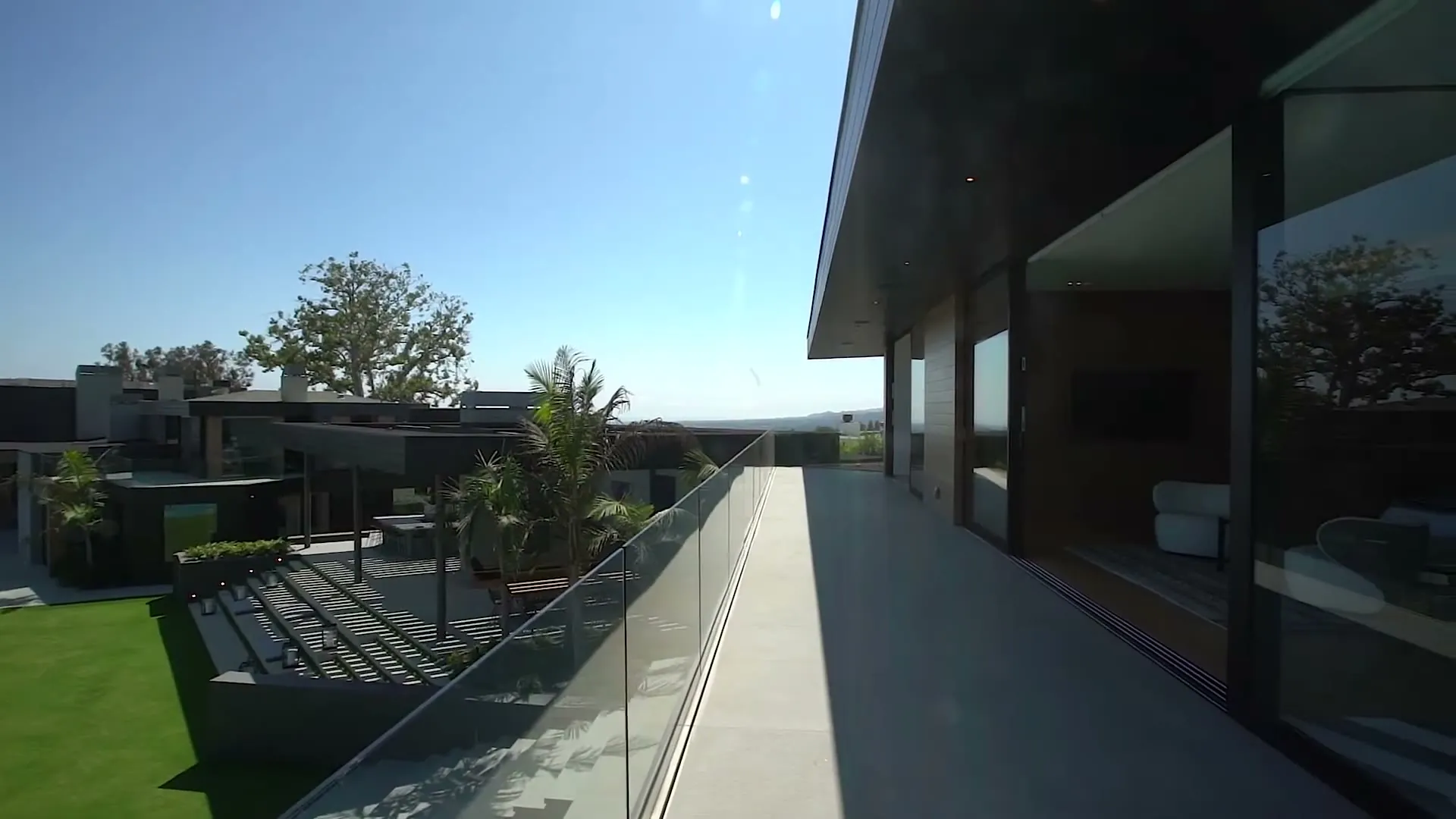 Frameless glass railing and sliding glass walls on the terrace of a Beverly Hills estate on Gilcrest Drive, glass and glazing by Versa Glass Co.