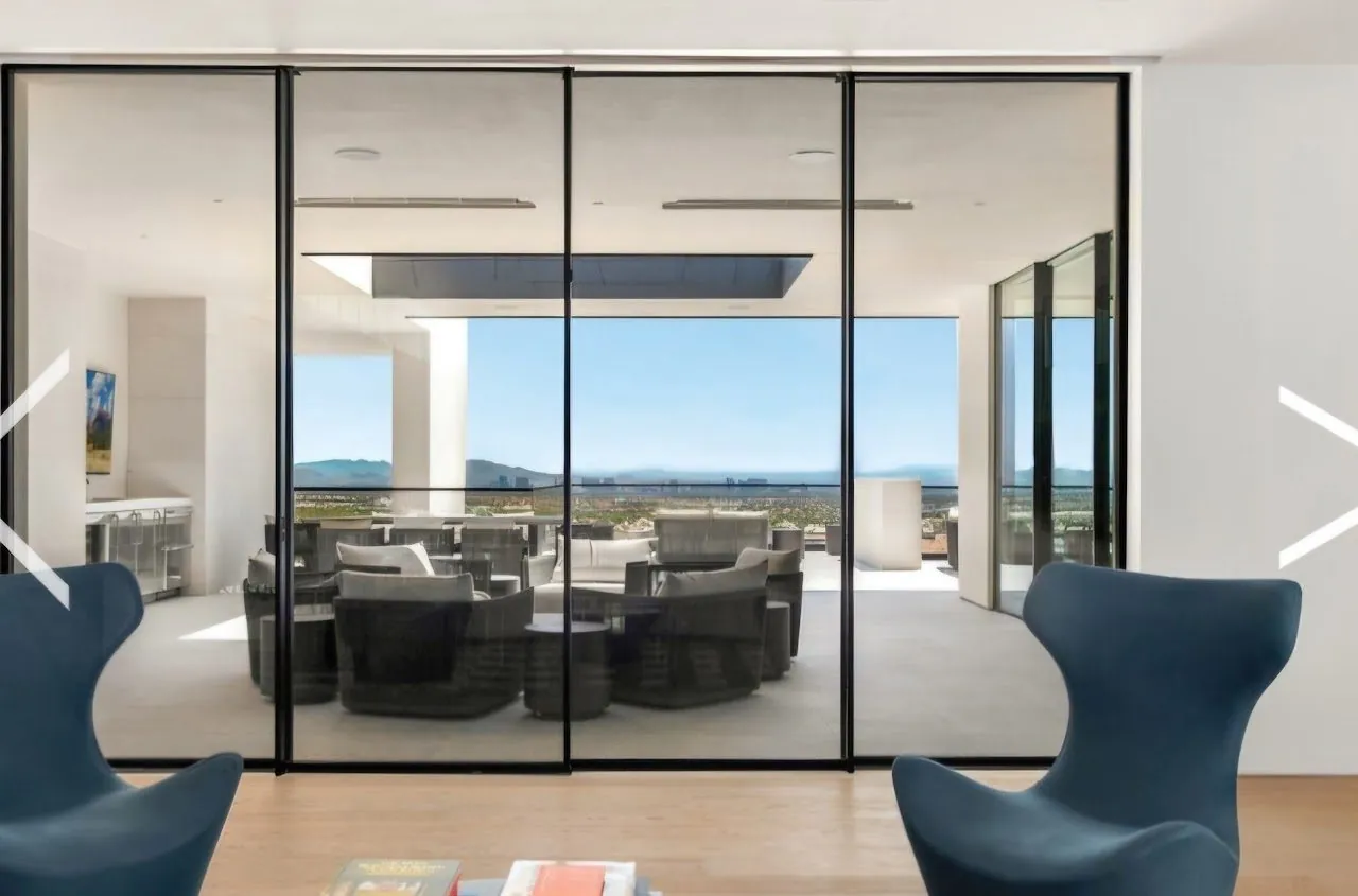Wall of Fleetwood sliding glass doors opening to an ocean-view living space, installed by Versa Glass Co.