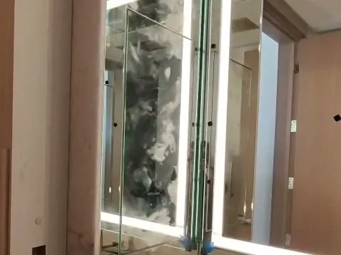 Backlit LED vanity mirrors with a swing-out mirror panel installed by Versa Glass Co. in a Los Angeles bathroom