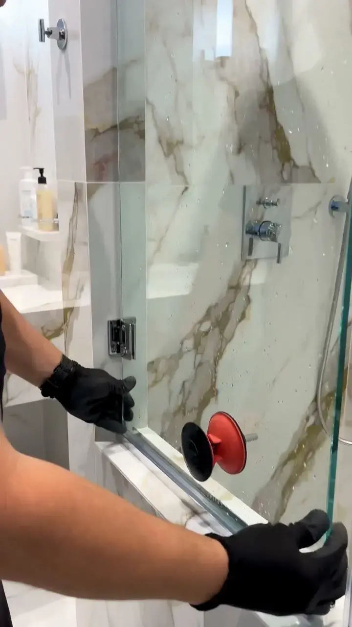 Frameless shower glass panel being set in a Los Angeles bathroom