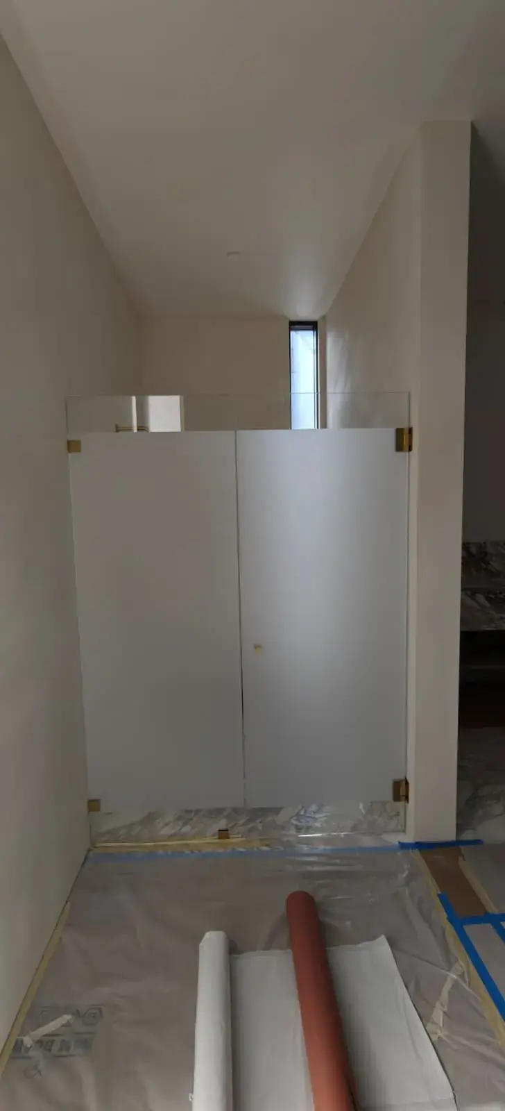 Finished steam shower enclosure with frosted Starphire double doors and a clear operable transom in a Los Angeles primary bathroom